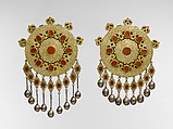 Pectoral Disc Ornament, One of a Pair, Silver; fire-gilded with engraving/punching, stylized floral terminations, openwork decoration, pendants, silver twisted wire chains, table cut carnelians, and bells/beads