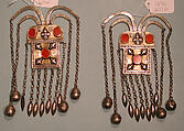 Boy's Amulet, One of a Pair, Silver, fire-gilded with gallery wire, stamped bead and applique decoration, rams' heads upper terminations, link chains, bells, embossed pendants and table cut carnelians