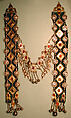 Dorsal Plait Ornament, Silver, fire-gilded and engraved/punched with stamped, beaded and applique decoration and table cut carnelians and slightly domed carbelians with silver link chains, bells/beads and embossed pendants