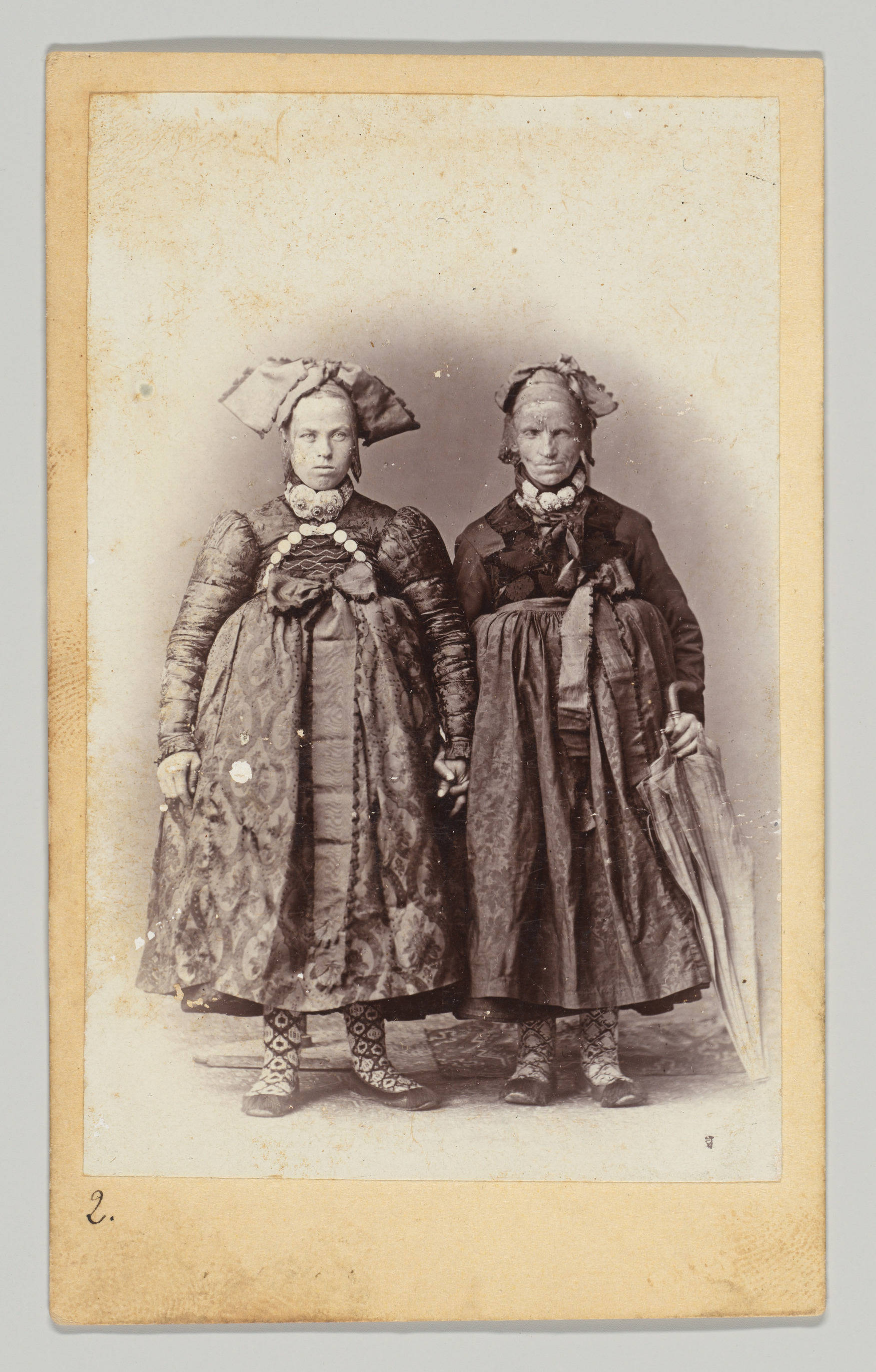 [Two Women in Regional Dress; Seen From Front and Back]