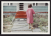 [Watering the garden in a pink housecoat, Casa Susanna, Hunter, NY]
, Andrea Susan  American, Chromogenic print