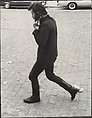 [Street Scene: Man in Boots Walking and Adjusting His Collar, New York City], Leon Levinstein  American, Gelatin silver print