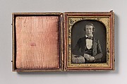 [Seated Young Man Resting Arm on Table Beside Daguerreotype Case], Unknown (American), Daguerreotype with applied color