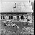 [Boy Lying on Ground in Front of House], Ralph Eugene Meatyard  American, Gelatin silver print