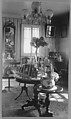 [Domestic Interior with Crystal Chandelier, Mirrors, Round Tables with Framed Photographs], Nancy Naumburg  American, Gelatin silver print