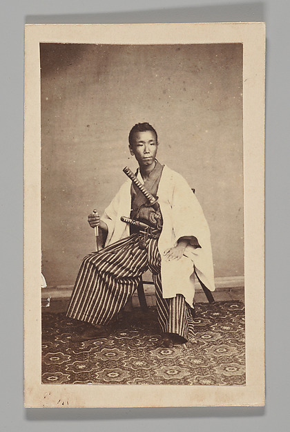 [Studio Portrait: Man Seated with Swords]