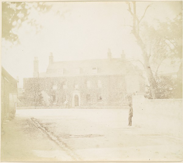 [Man in Courtyard Before House]