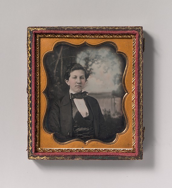 [Young Man Seated in Front of Painted Outdoor Backdrop]