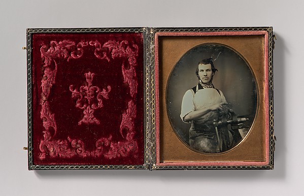 [Metalworker in Apron Working with a Vise]