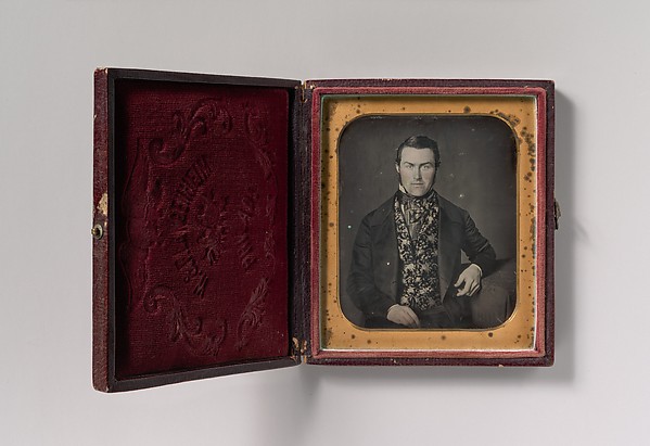 [Seated Man in Floral Vest]