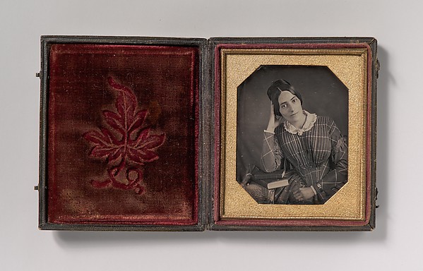 [Young Woman with Elbow Resting on Small Pile of Books and Head on Hand]
