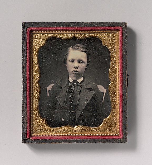 [Boy in Wide Lapelled Coat, Seated in Chair]
