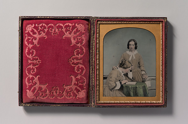 [Two Women Wearing Striped Dresses, One Standing, the Other Seated]