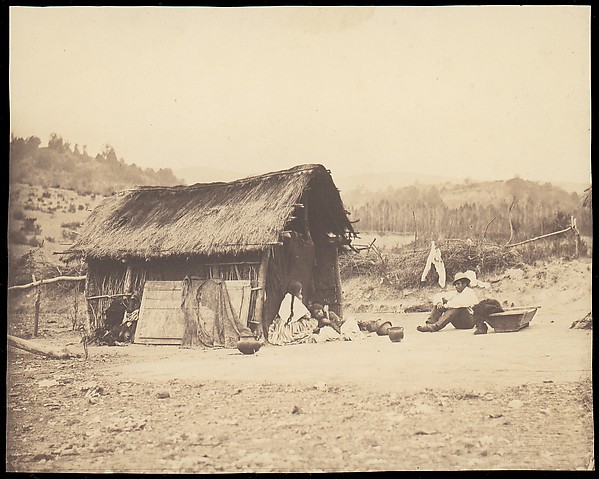 [Family Seated by Thatched Hut, South America]